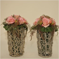 Glazen vaas in bamboo frame met strak roze rozenboeket.